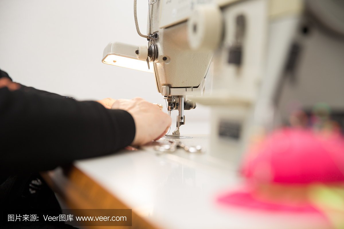 女裁缝用缝纫机缝制织物,特写